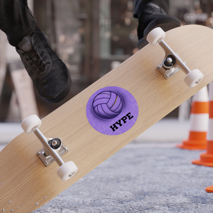 A wooden skateboard with a purple circular &